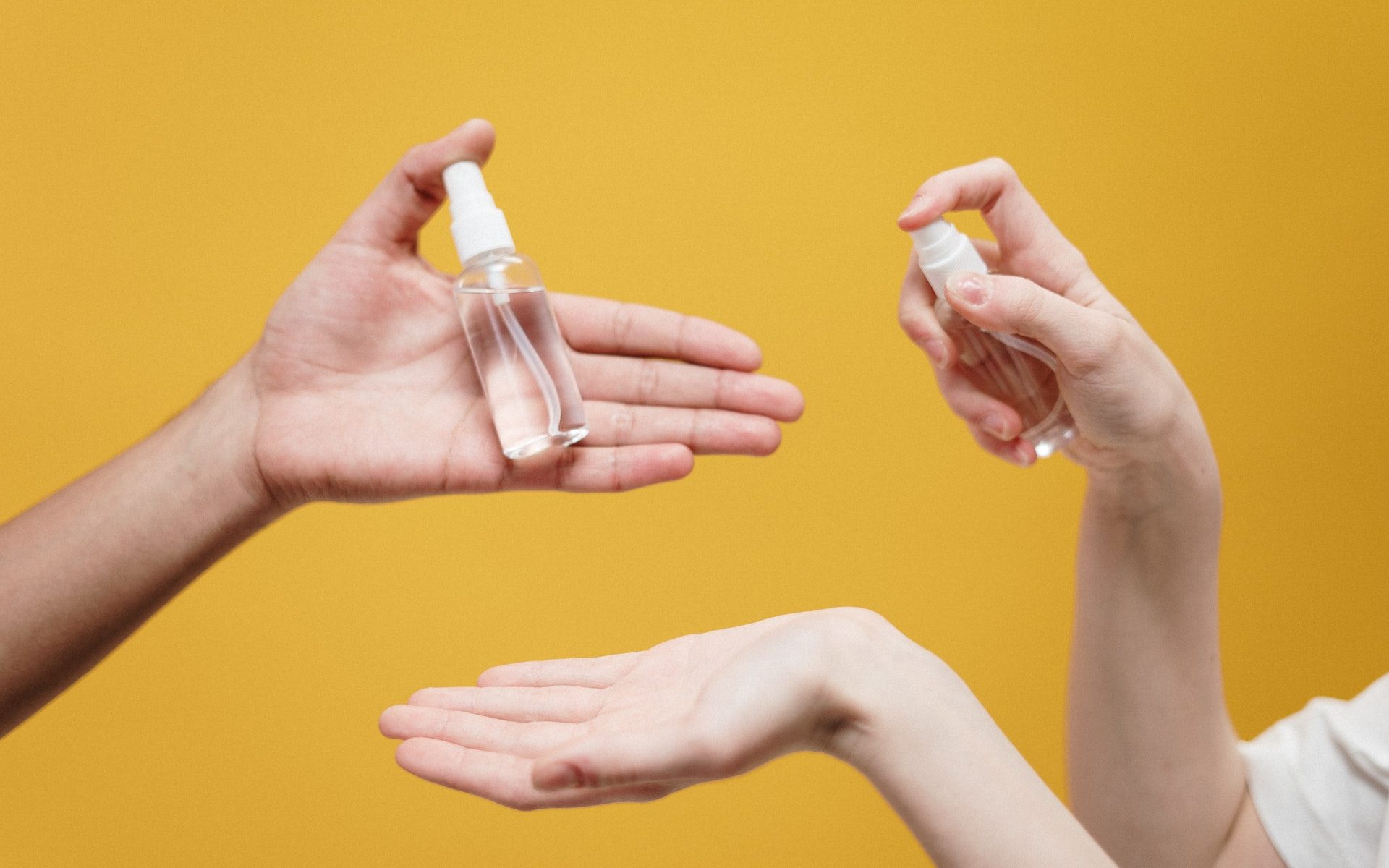 people-holding-clear-glass-bottles