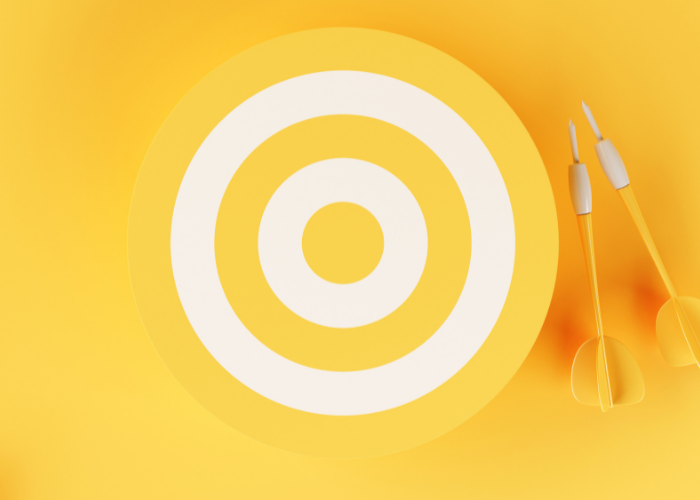 Yellow and white dart board with yellow darts on a yellow background